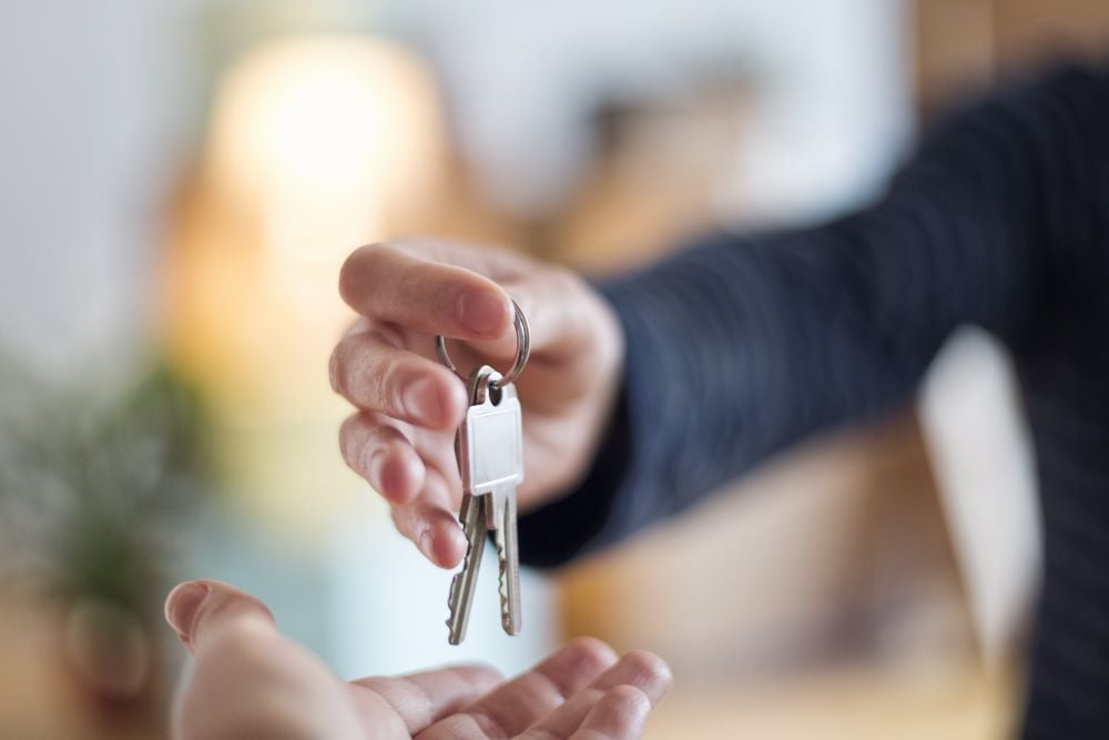 business person passing keys to a an open hand